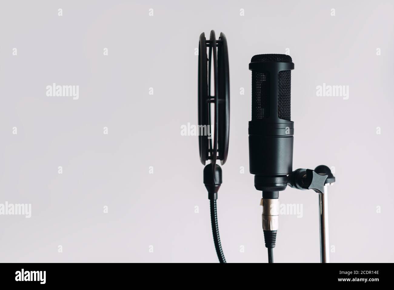 Black condenser microphone on stand with pop filter isolated on gray background Stock Photo