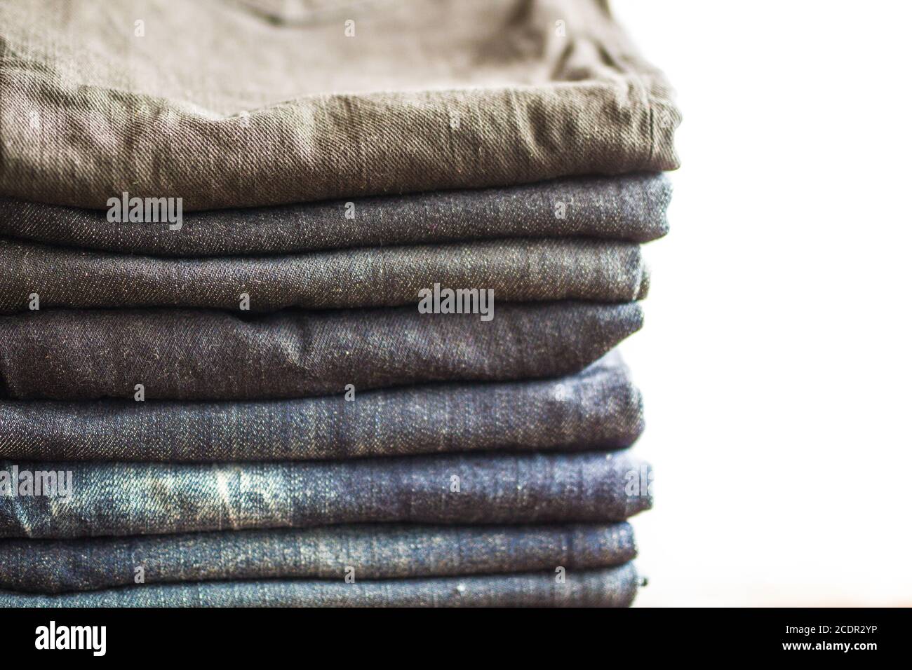 Stack of jeans on white background Stock Photo