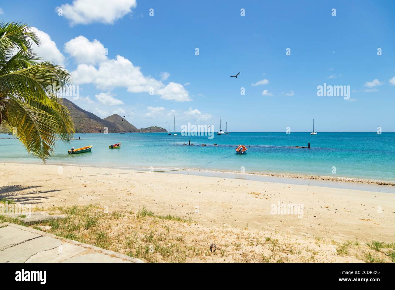 Tropical beach on a bright day, in Gros- Islet, a fishing village. Apparently it was not a good day for fishing as boats are anchored. Stock Photo
