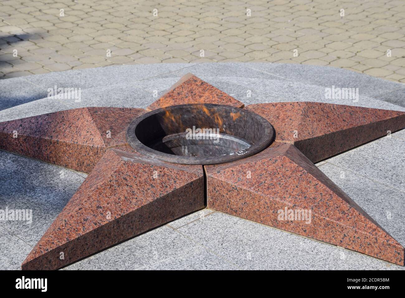 Burning of eternal fire. Five-pointed star made of granite memorial to the memory of killed soldiers Stock Photo