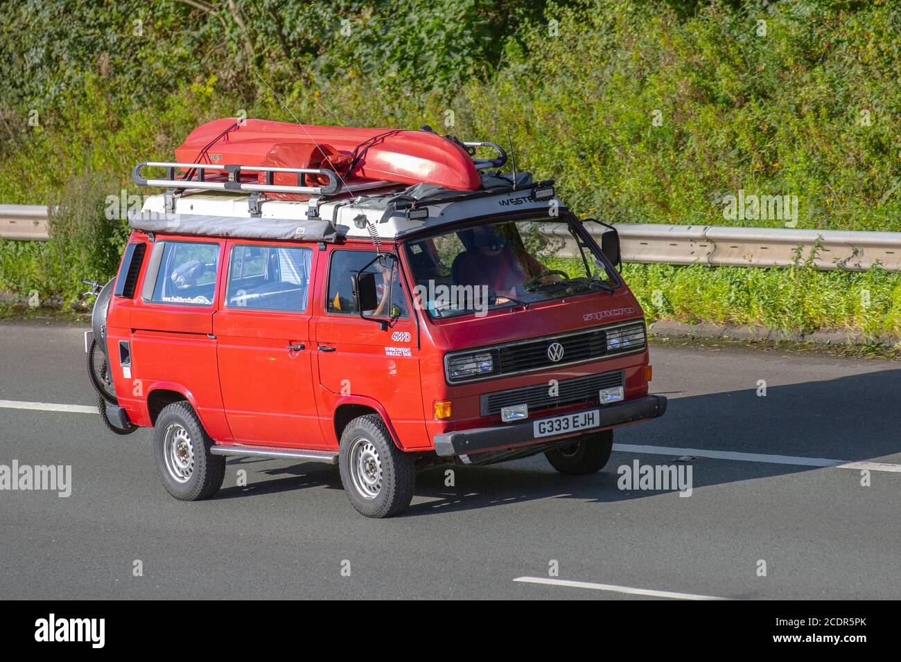 1989 80s red VW Volkswagen; Caravans and Motorhomes, campervans on Britain's roads, RV leisure vehicle, family holidays, caravanette vacations, Touring caravan holiday, van conversions, Vanagon autohome, life on the road, Dormobile Stock Photo
