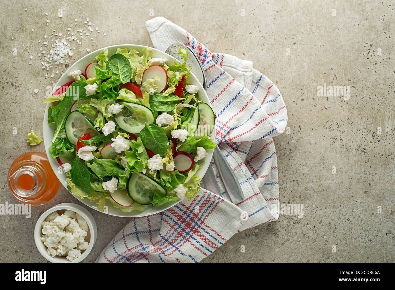 Lettuce salad with mixed vegetables and fresh cheese curd close up Stock Photo