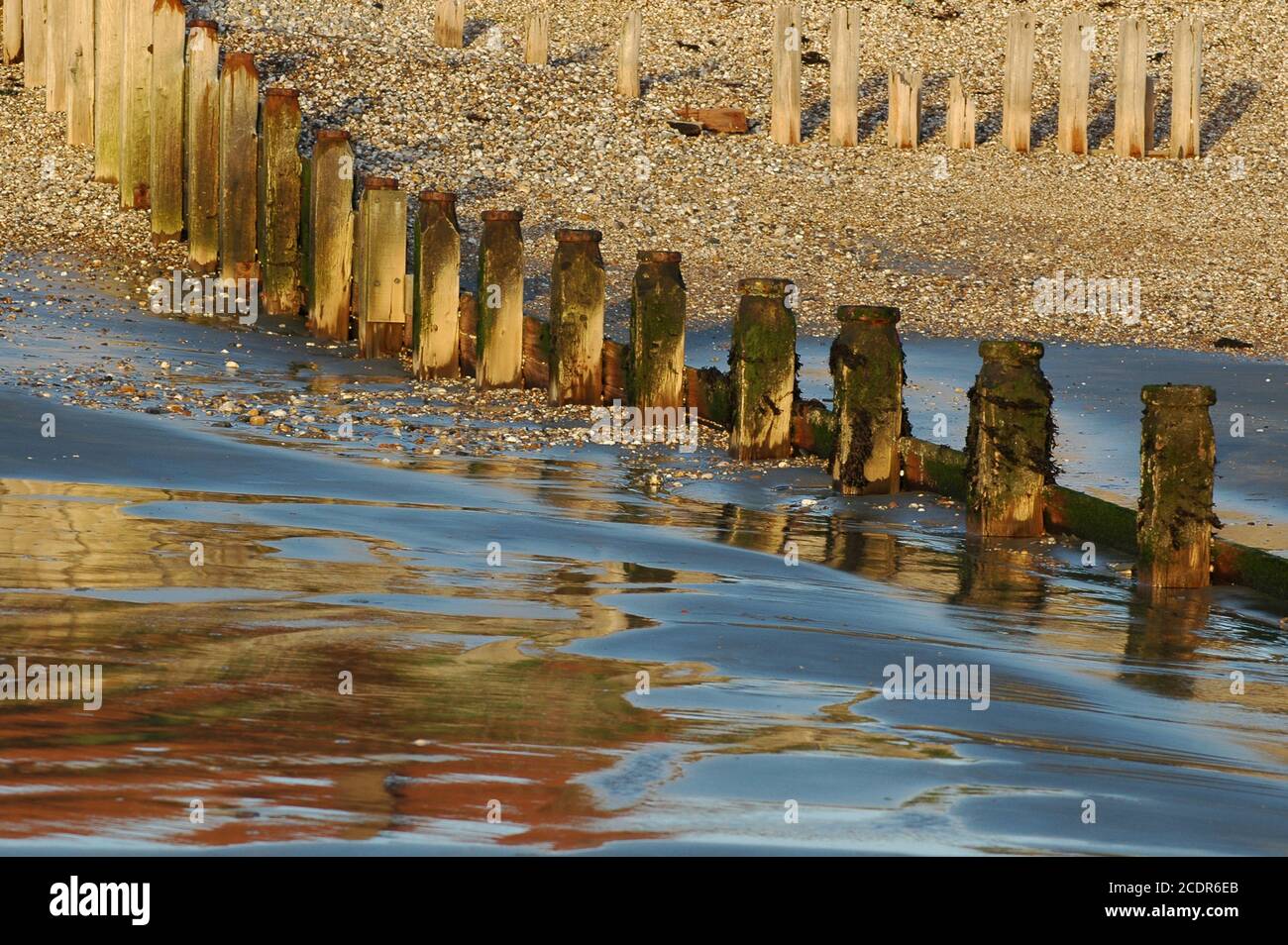 Breakwaters at rapidly retreating tide,  East Wittering / West Wittering beach, January. West Sussex. Stock Photo