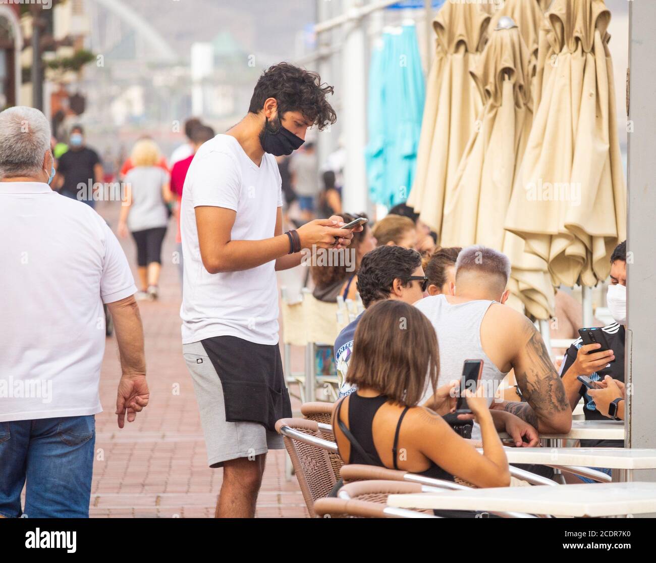 Las Palmas, Gran Canaria, Canary Islands, Spain. 28th August, 2020. Tourists  wearing face masks on the city beach in Las Palmas on Gran Canaria. The Canary Islands have seen a huge spike in Coronavirus infections in August, with Las Palmas registering the most cases. Credit: Alan Dawson/Alamy Live News Stock Photo