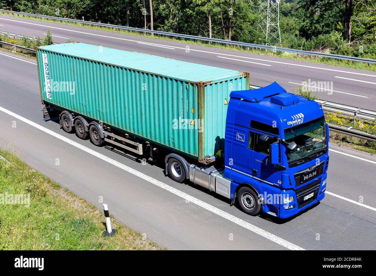 MAN TGX truck with Dong Fang container on motorway. Stock Photo