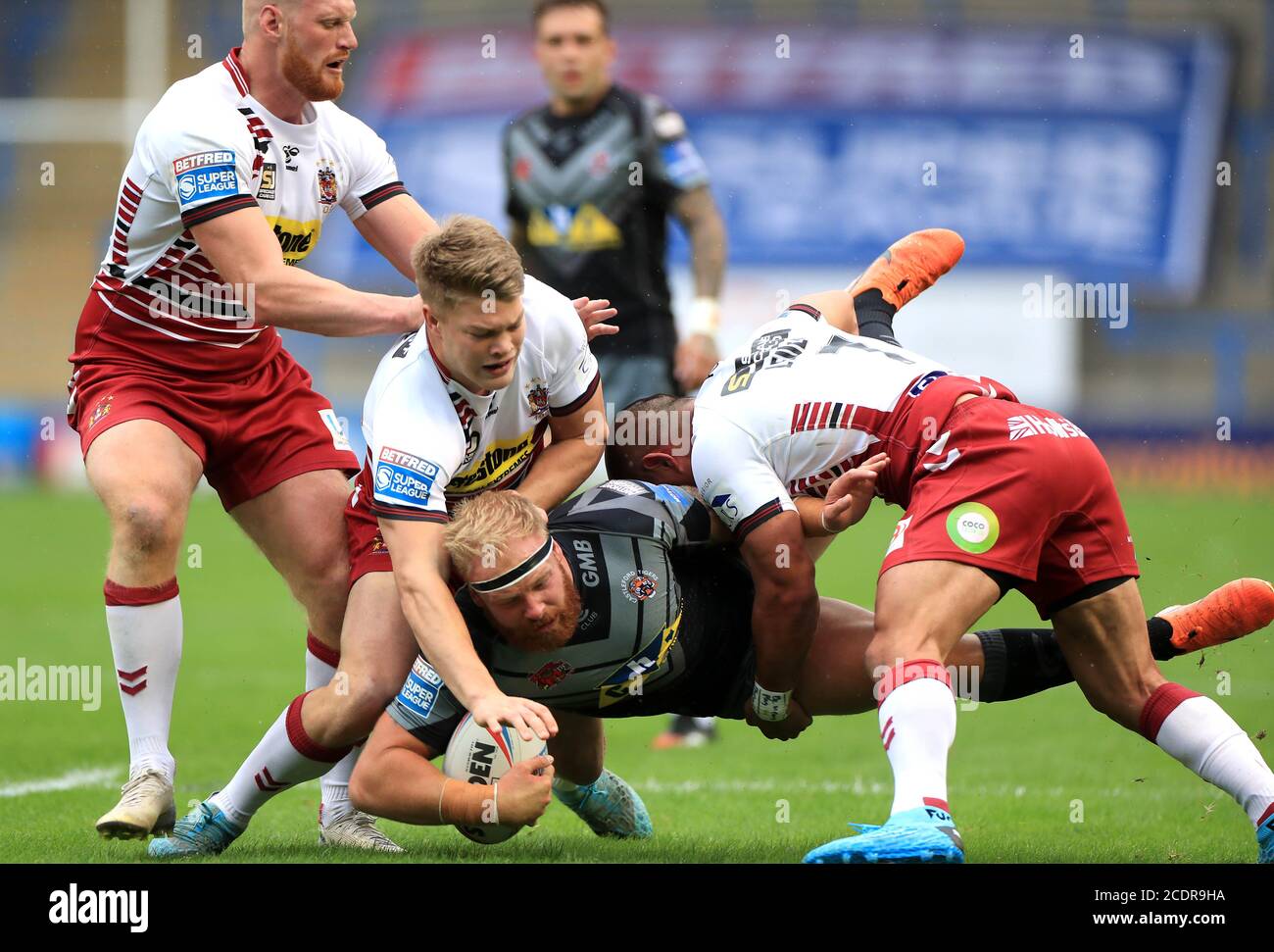 Castleford Tigers Oliver Holmes (centre) is tackled by Wigan Warriors Morgan Smithies (left) and Thomas Leuluai during the Super League match at the Halliwell Jones Stadium, Warrington Stock Photo