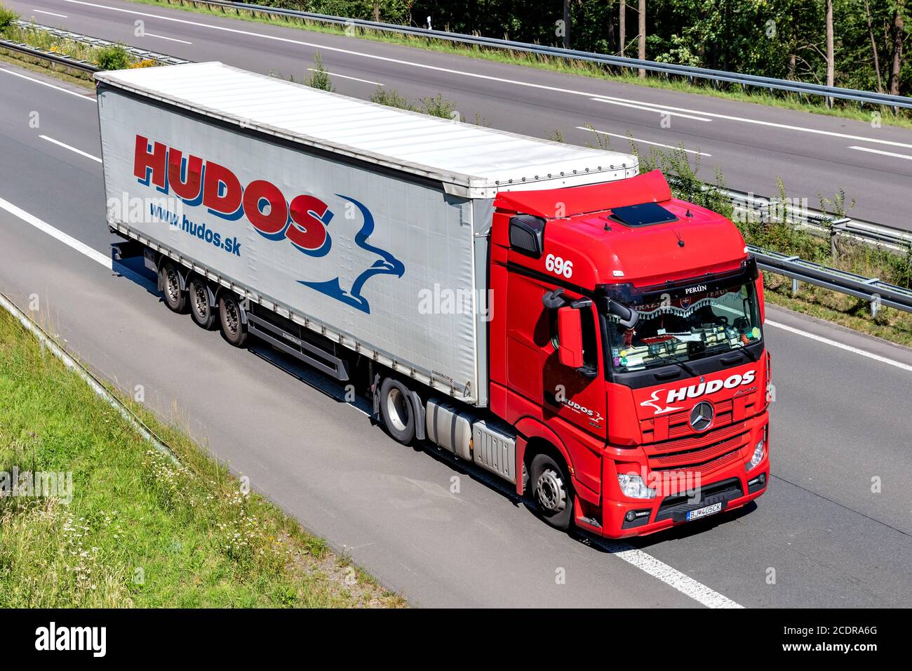Hudos Mercedes-Benz Actros truck with curtainside trailer on motorway. Stock Photo