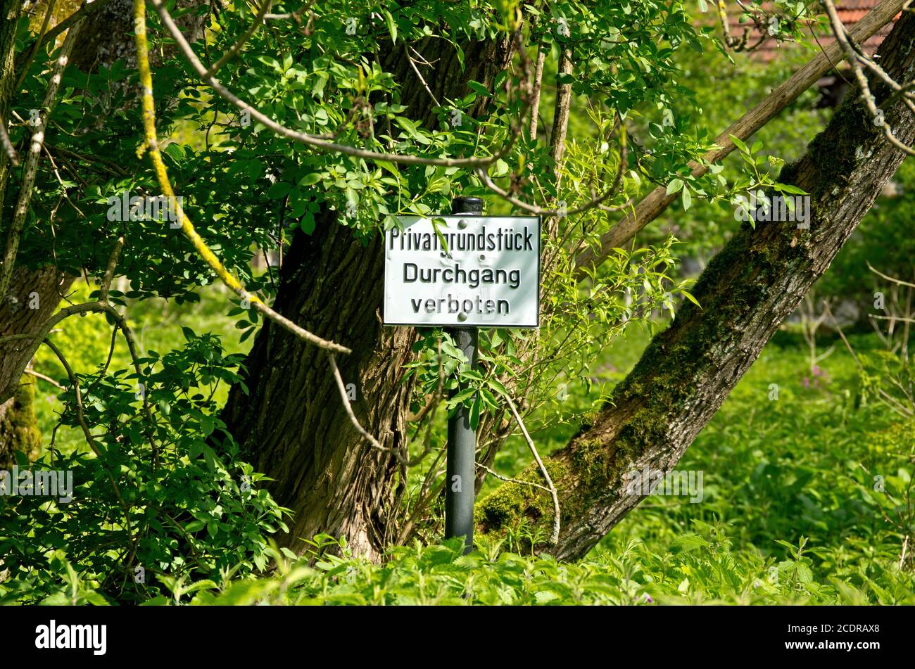 Sign in German language in front of an overgrown property private