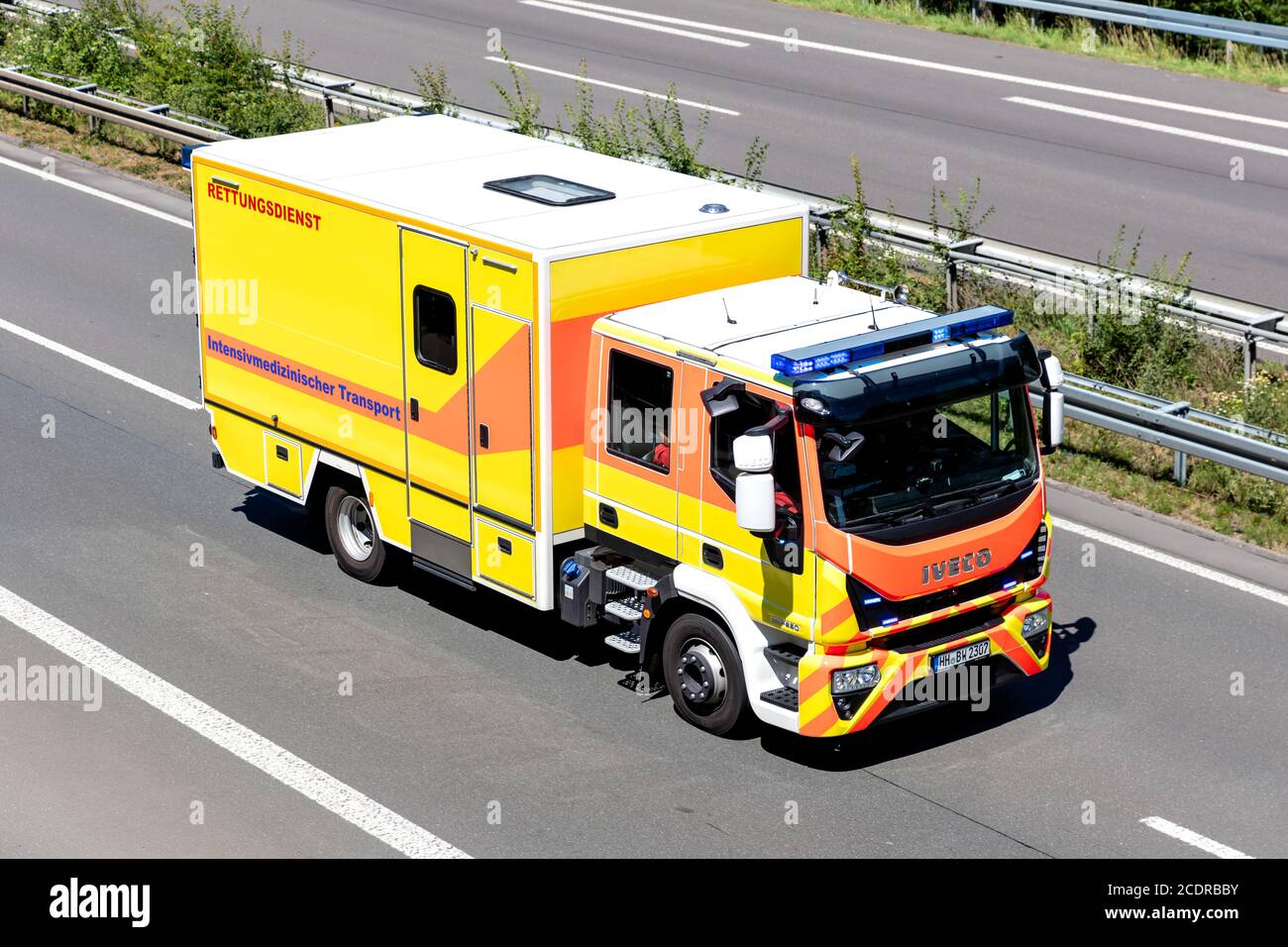 intensive care ambulance with active blue emergency vehicle lighting on motorway. Stock Photo