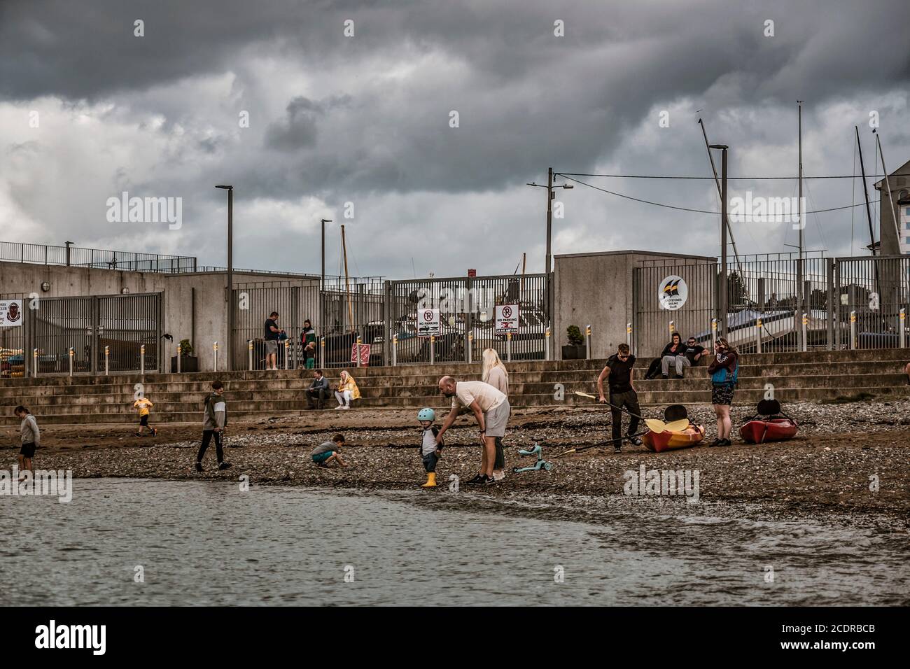 Visiting Greystones. Playing on the beach in front of Sailing club Stock Photo Alamy