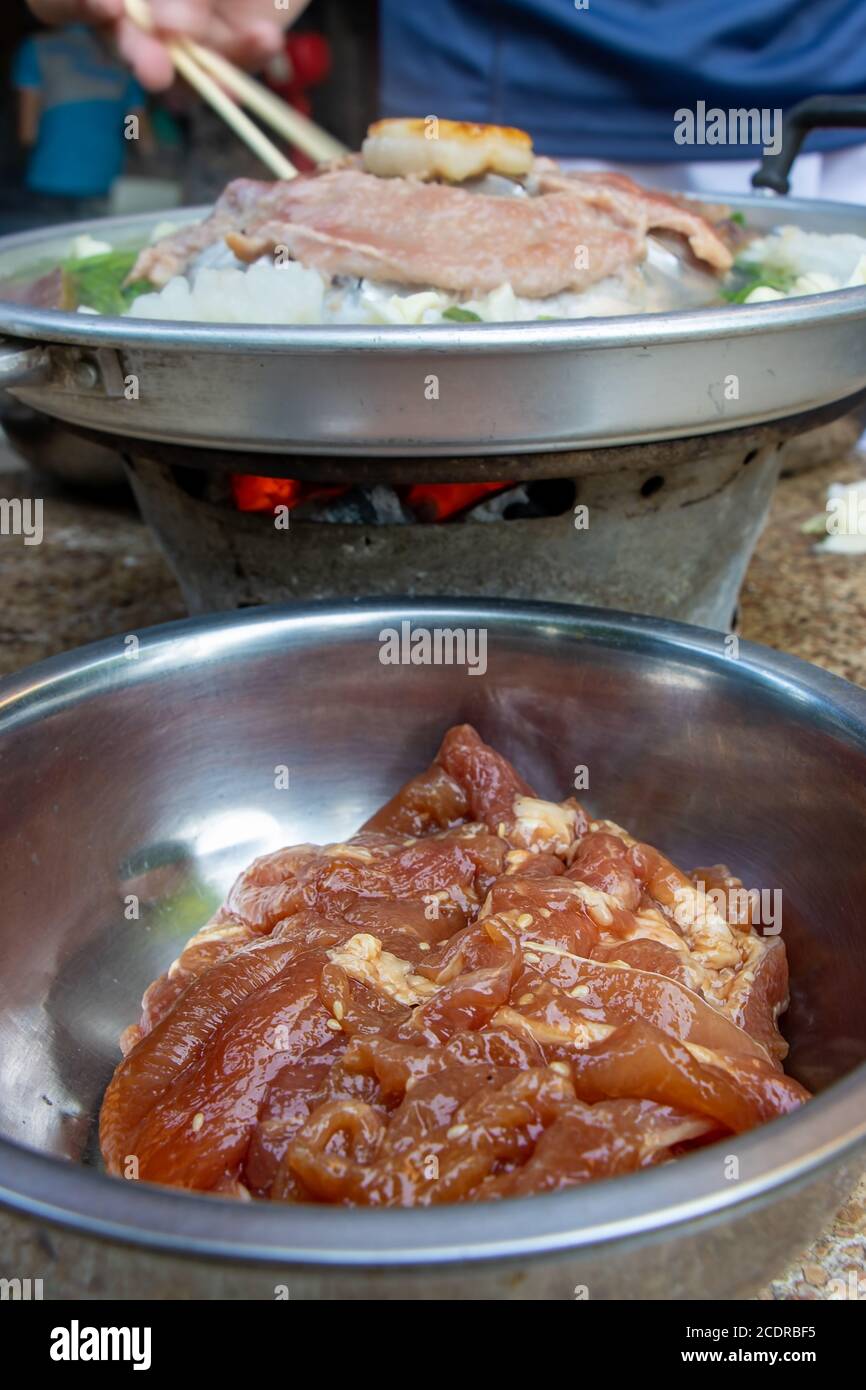 https://c8.alamy.com/comp/2CDRBF5/a-raw-pork-in-a-bowl-ready-for-grilling-at-thai-barbecue-style-a-preparation-of-roasted-meat-with-sauce-of-vegetable-on-hot-pot-mu-kratha-close-up-2CDRBF5.jpg