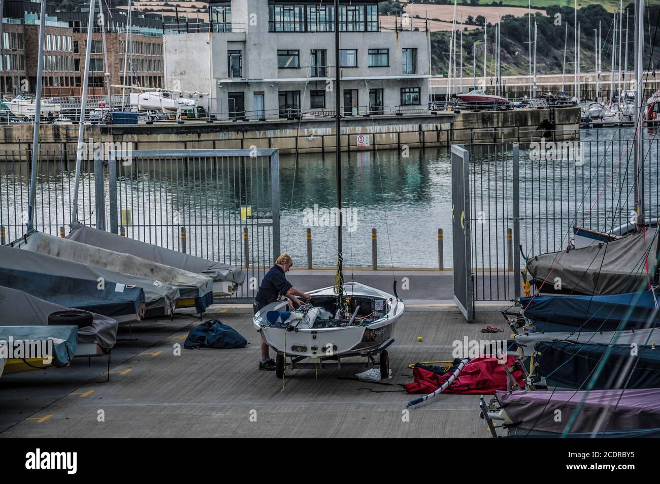 Visiting Greystones. Lady preparing her boat to the sea in Sailing club Stock Photo Alamy