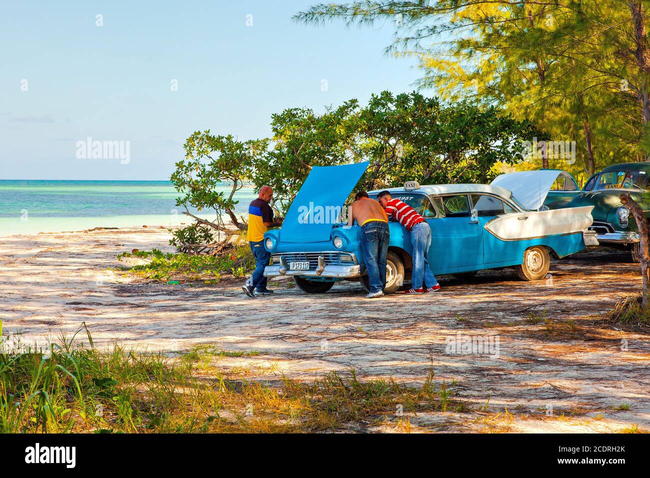 Cayo Jutias, Cuba: Cubans repair an old classic American vintage taxi car Stock Photo