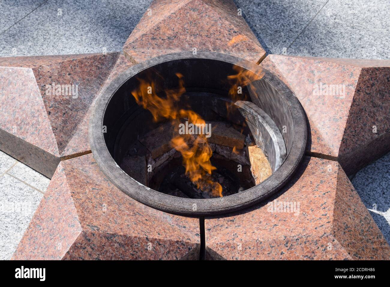 Burning of eternal fire. Five-pointed star made of granite memorial to the memory of killed soldiers Stock Photo