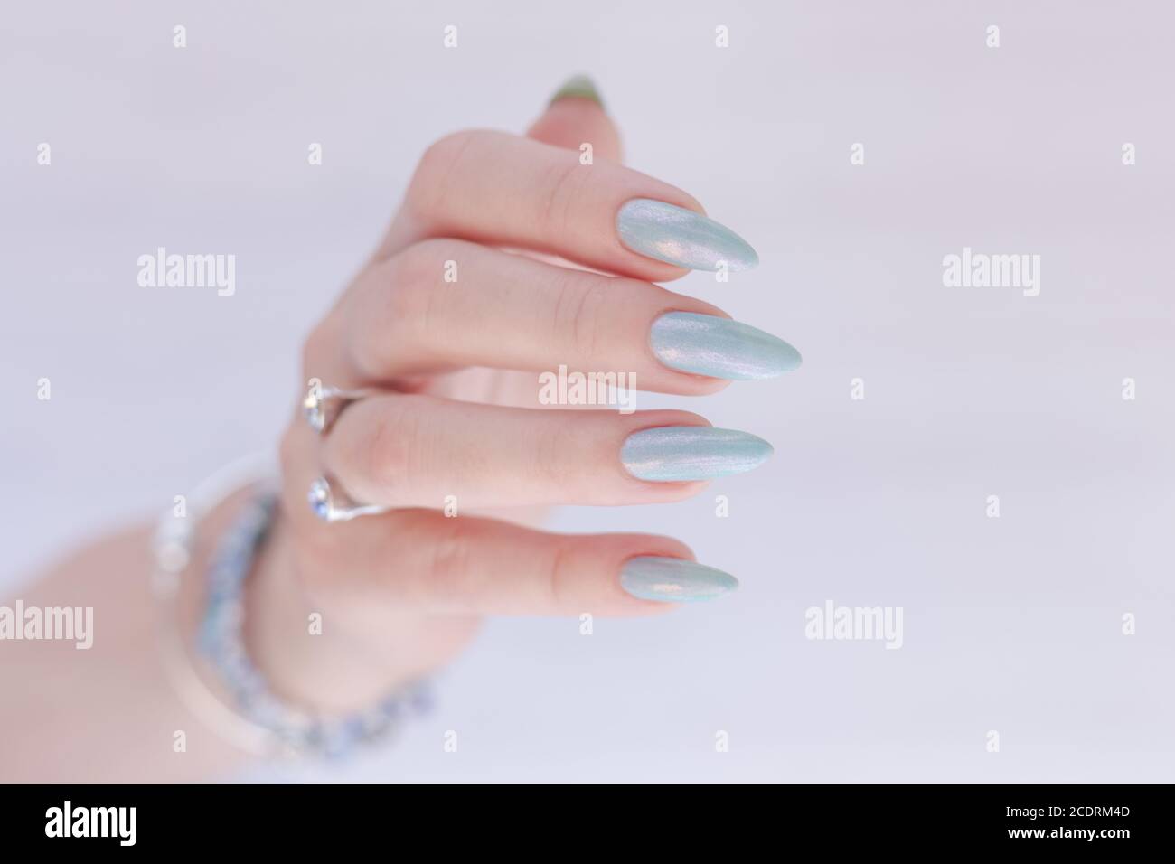 Female Hand With Long Nails And Light Blue Manicure With Bottles Of Nail Polish Stock Photo Alamy