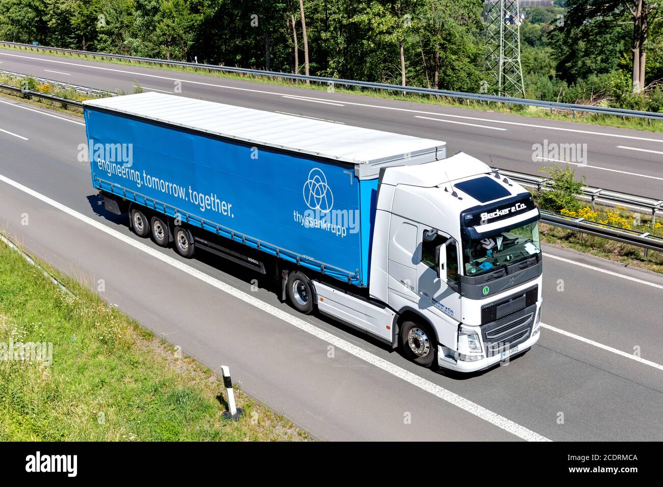 Becker & Co. Volvo FH truck with ThyssenKrupp curtainside trailer on motorway. Stock Photo