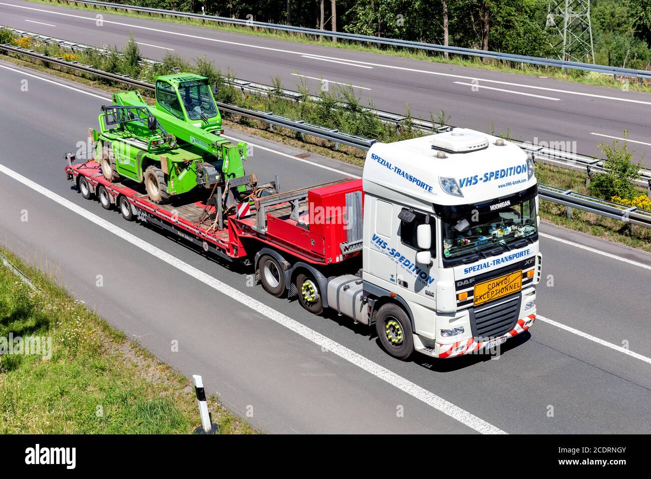 VHS-Spedition DAF XF flatbed truck with Merlo telescopic handler on motorway. Stock Photo