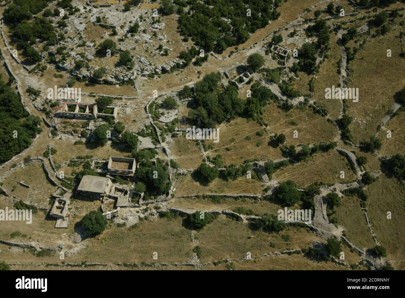 Walls and fences of abandoned farms and villages lie in ruin near the Croatia Bosnia border. Stock Photo