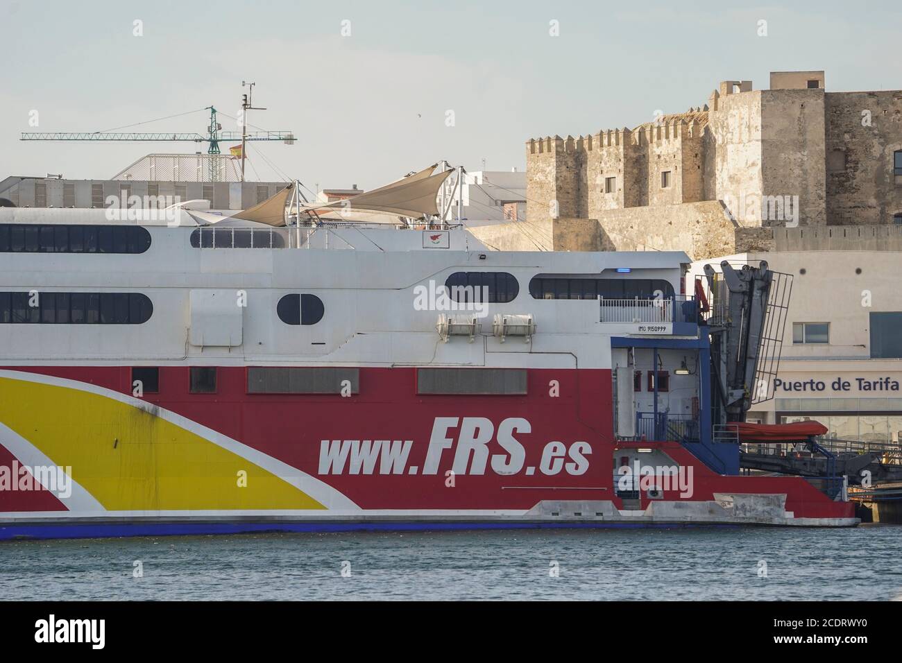 Tarifa Spain. Tarifa ferry, in Port of Tarifa, with Guzman castle behind,Costa de la luz, Spain. Stock Photo
