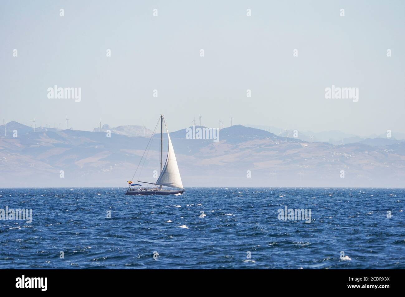 Sailboat on open sea, at strait of Gibraltar, Morocco in background, Spain. Stock Photo