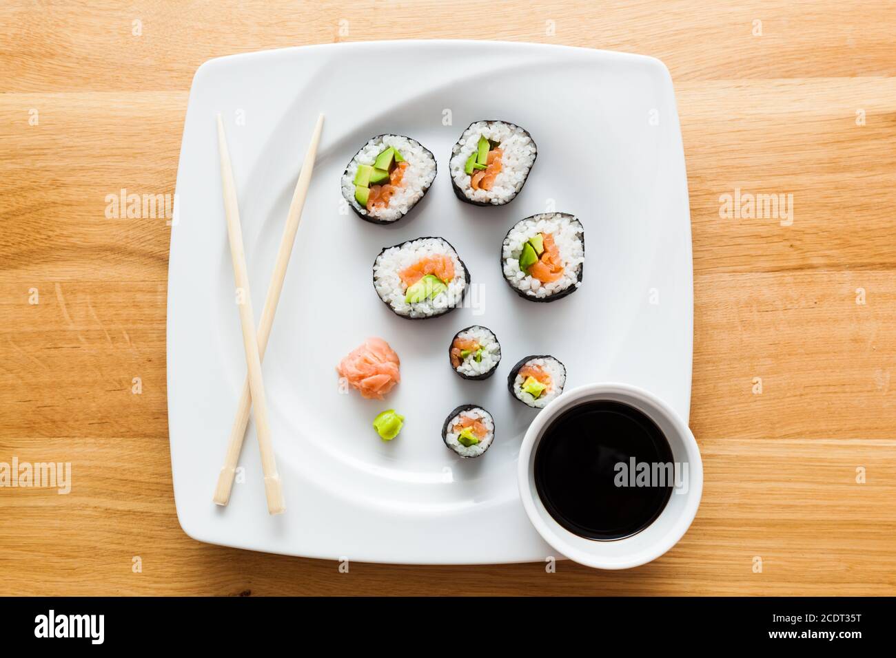 Sushi with salmon, avocado, rice in seaweed served with wasabi and ginger. Stock Photo