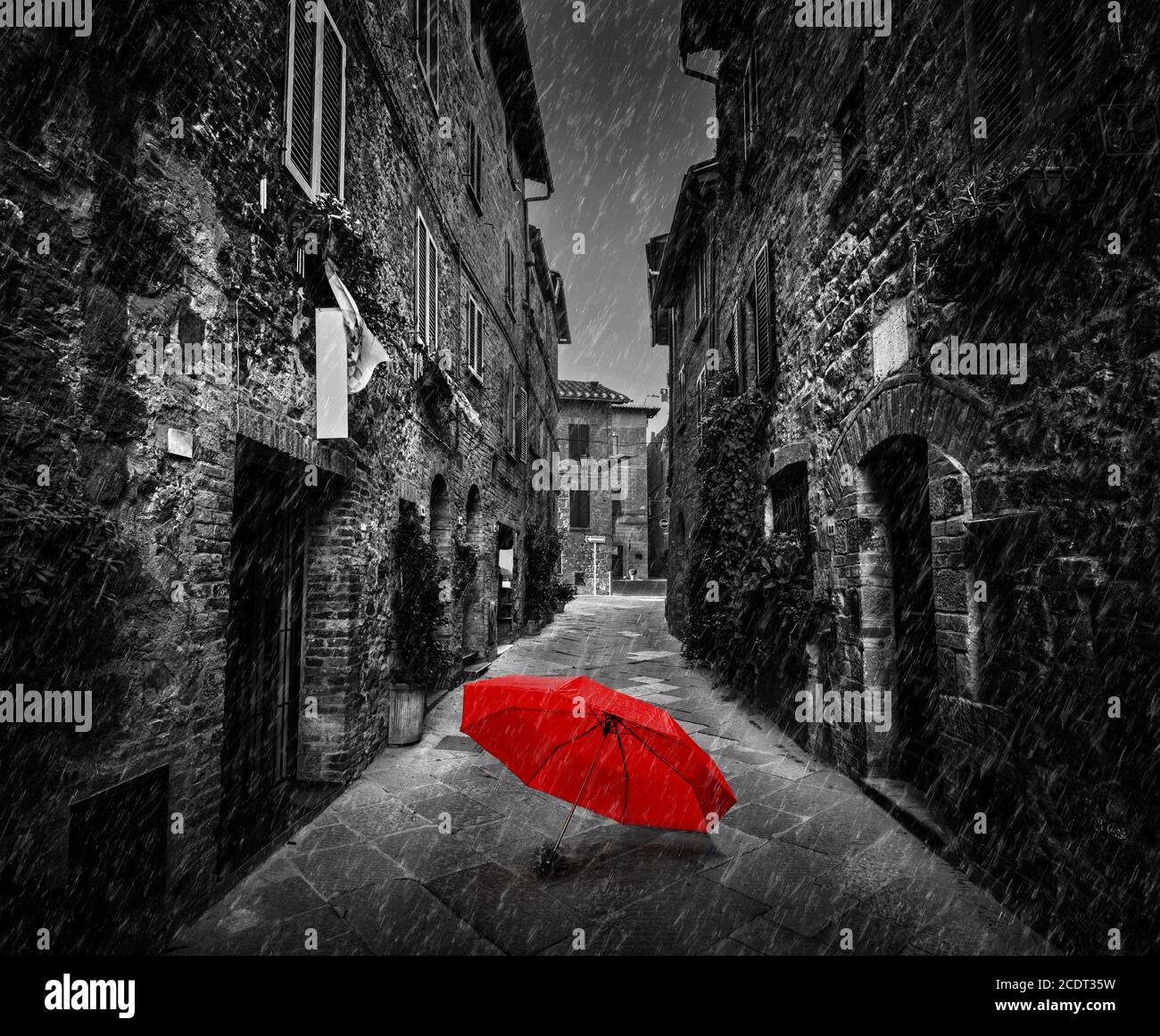 Umbrella on dark street in an old Italian town in Tuscany, Italy. Raining. Stock Photo