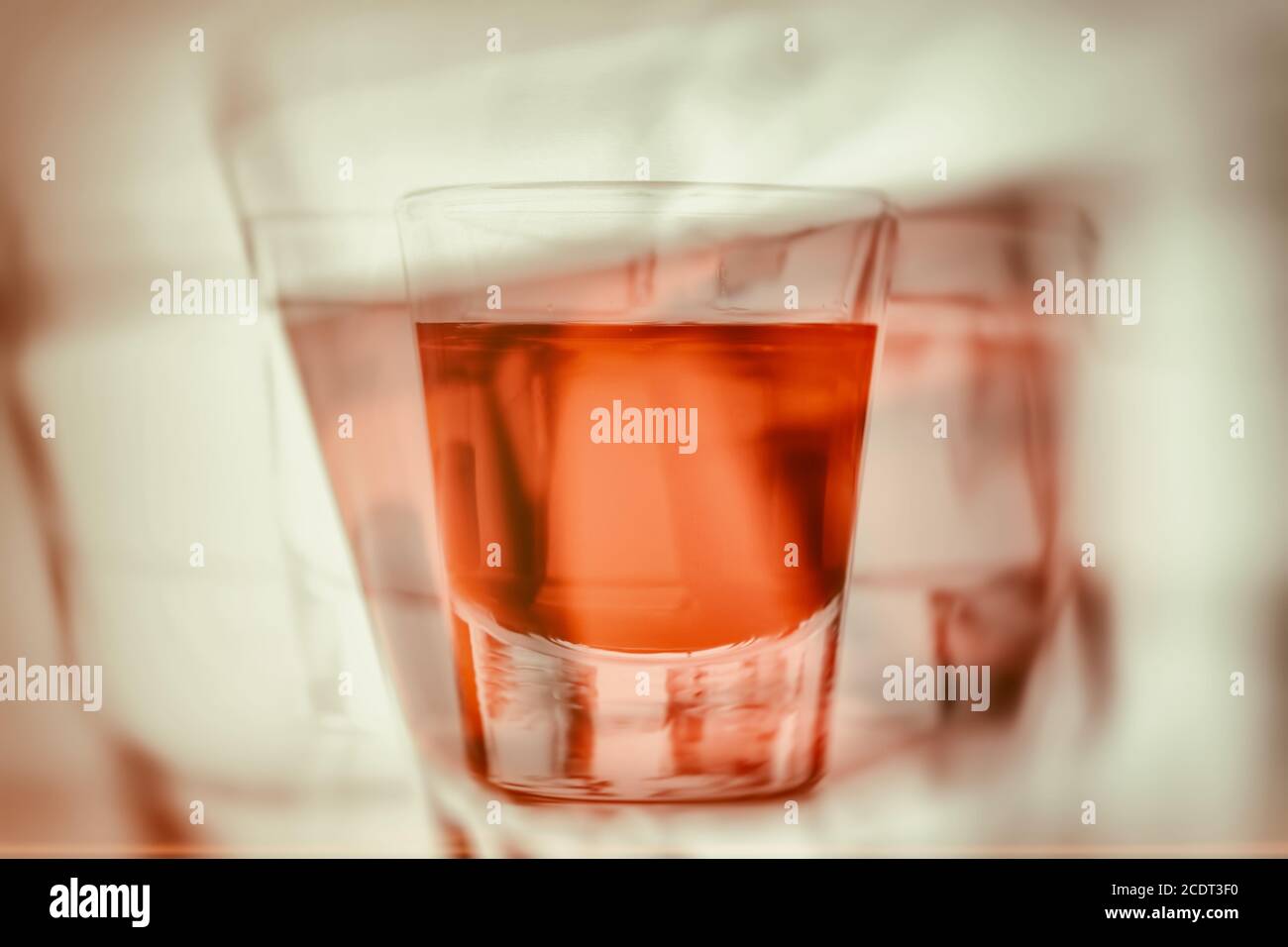 Abstract first person perspective of being drunk and reaching for another glass of alcohol. Stock Photo