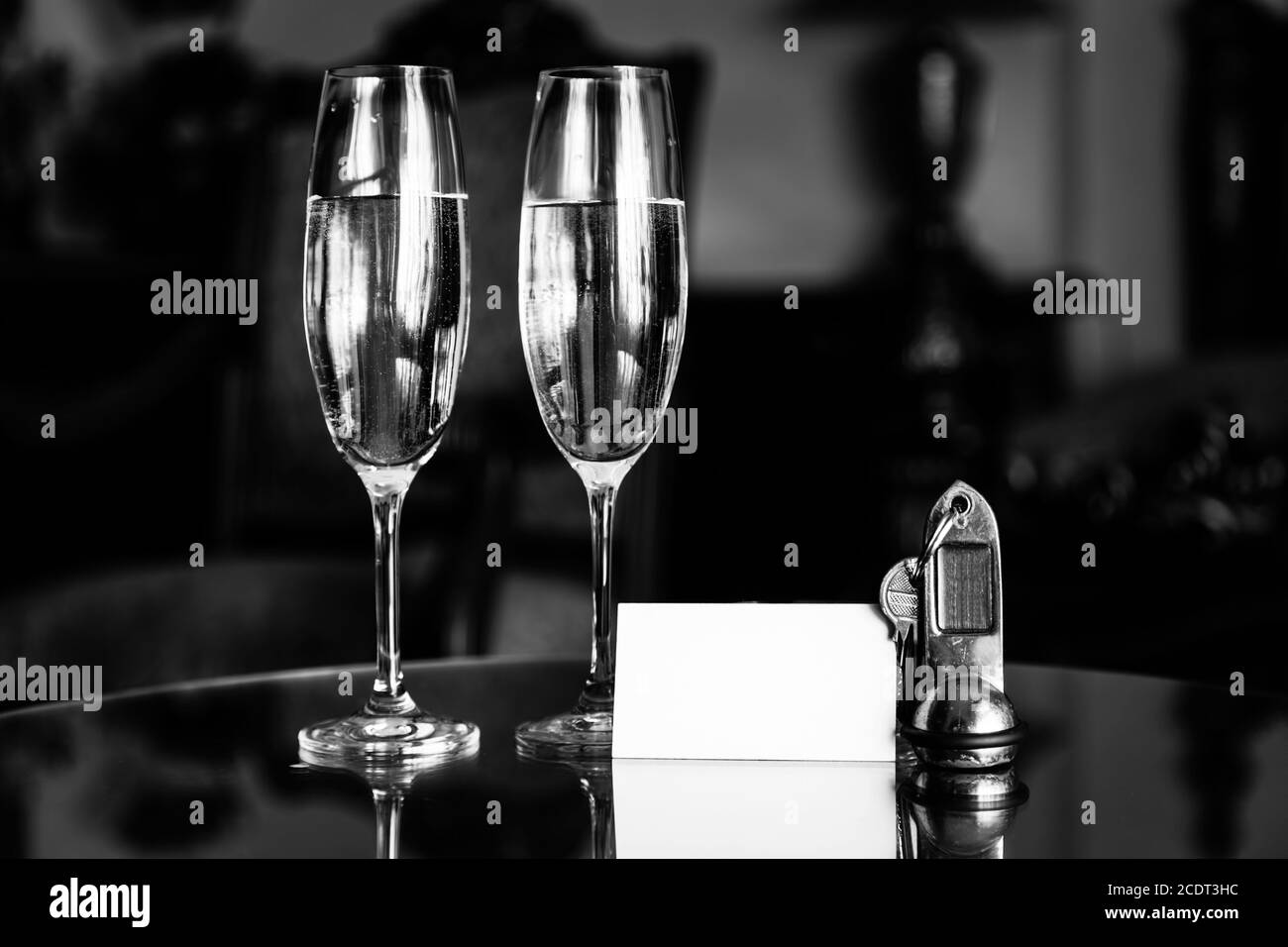 Full champagne glasses, antique keys and blank white card. Luxury hotel apartment Stock Photo