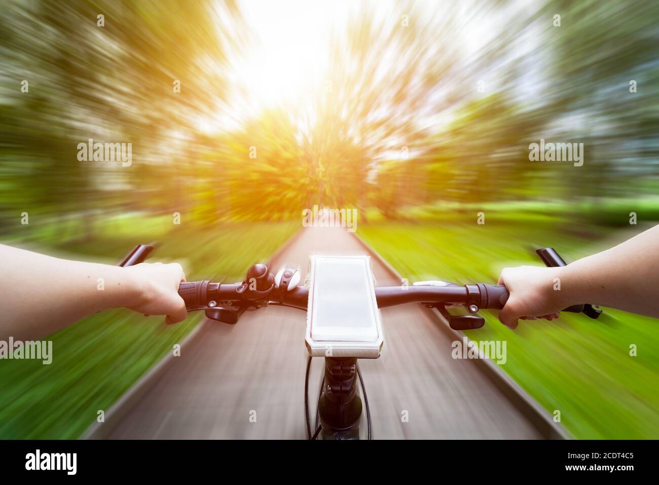 Riding a bike first person perspective. Smartphone on handlebar. Speed motion blur Stock Photo