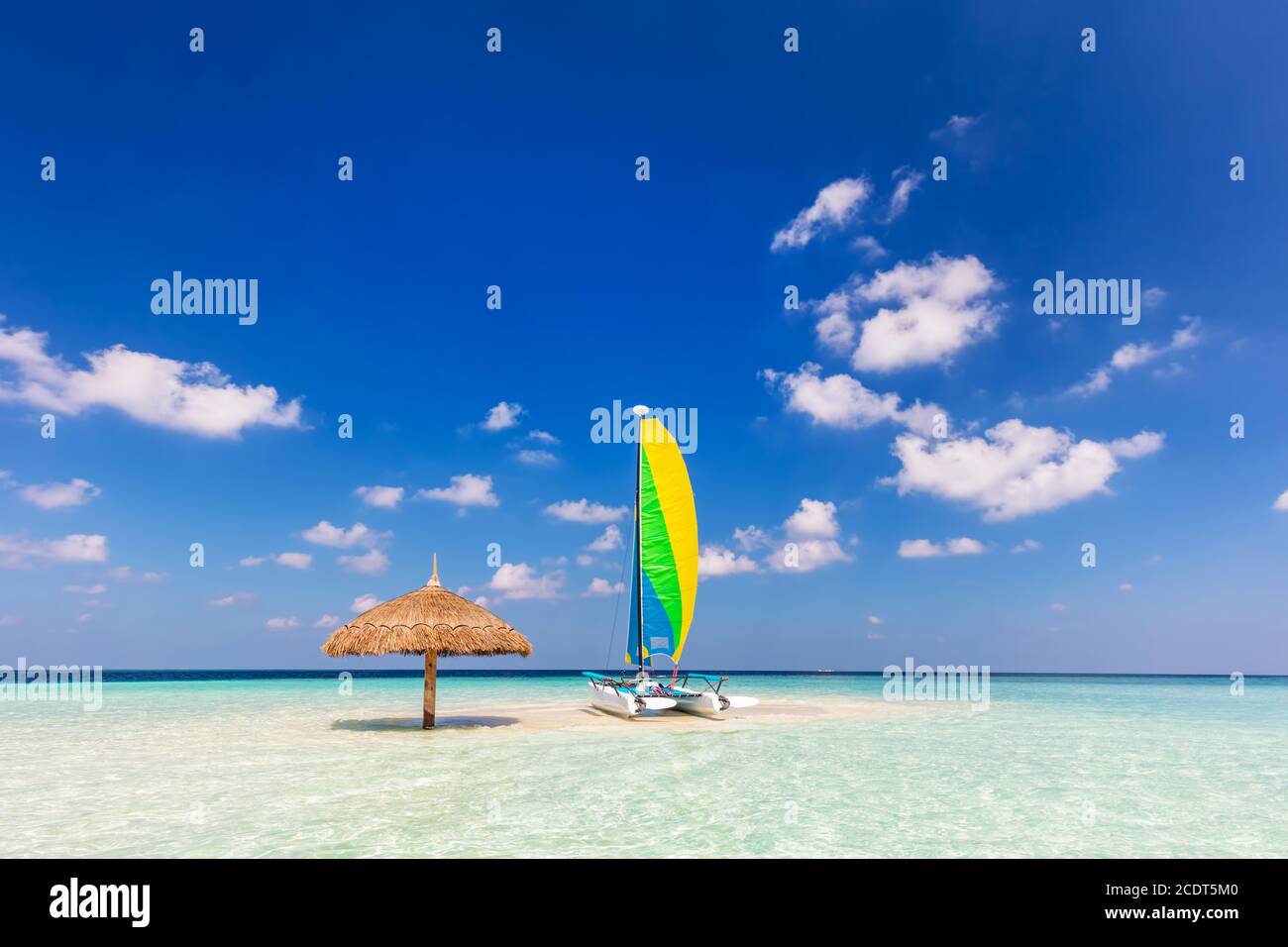 Catamaran on tropical sandbank island with sunshade, Maldives. Indian Ocean Stock Photo