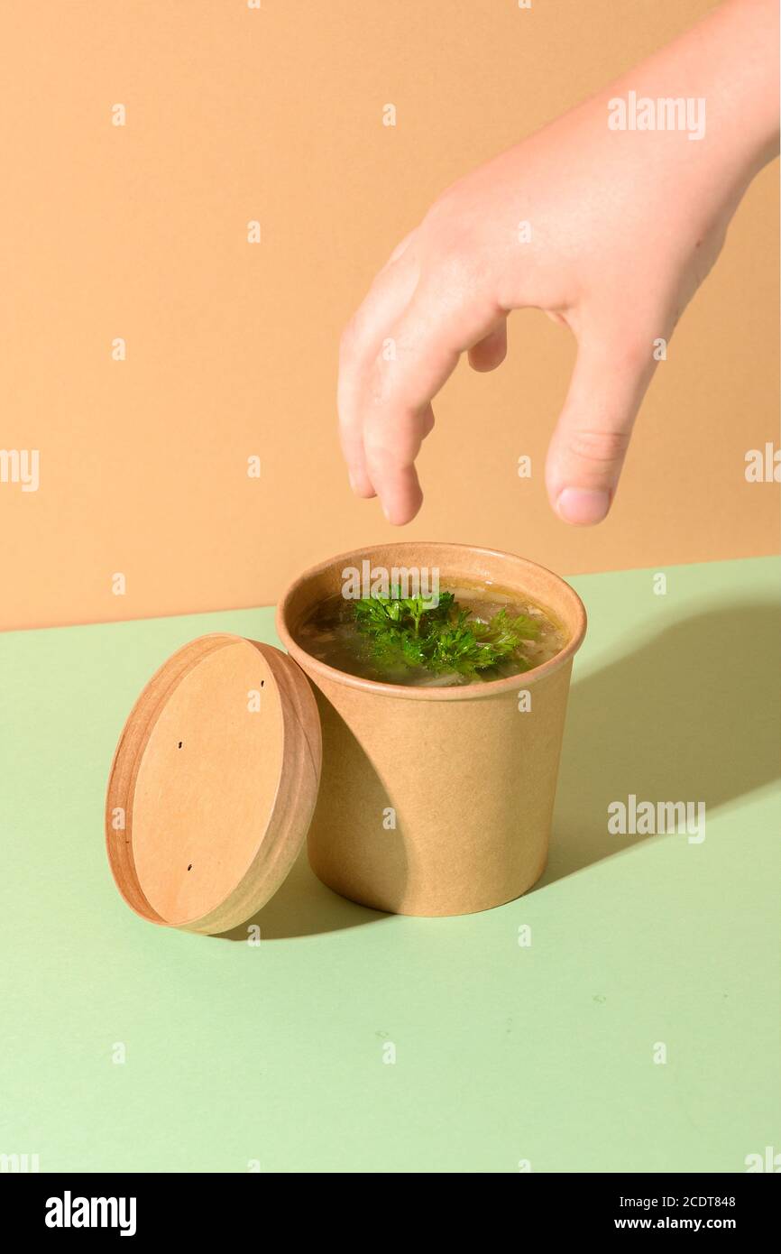 Healthy chicken broth with greens and child hand. Creative minimal