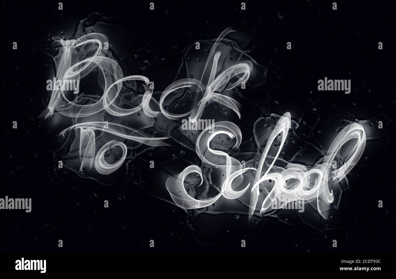 Back to school words lettering made by white fire or flame over black ice reflection background Stock Photo