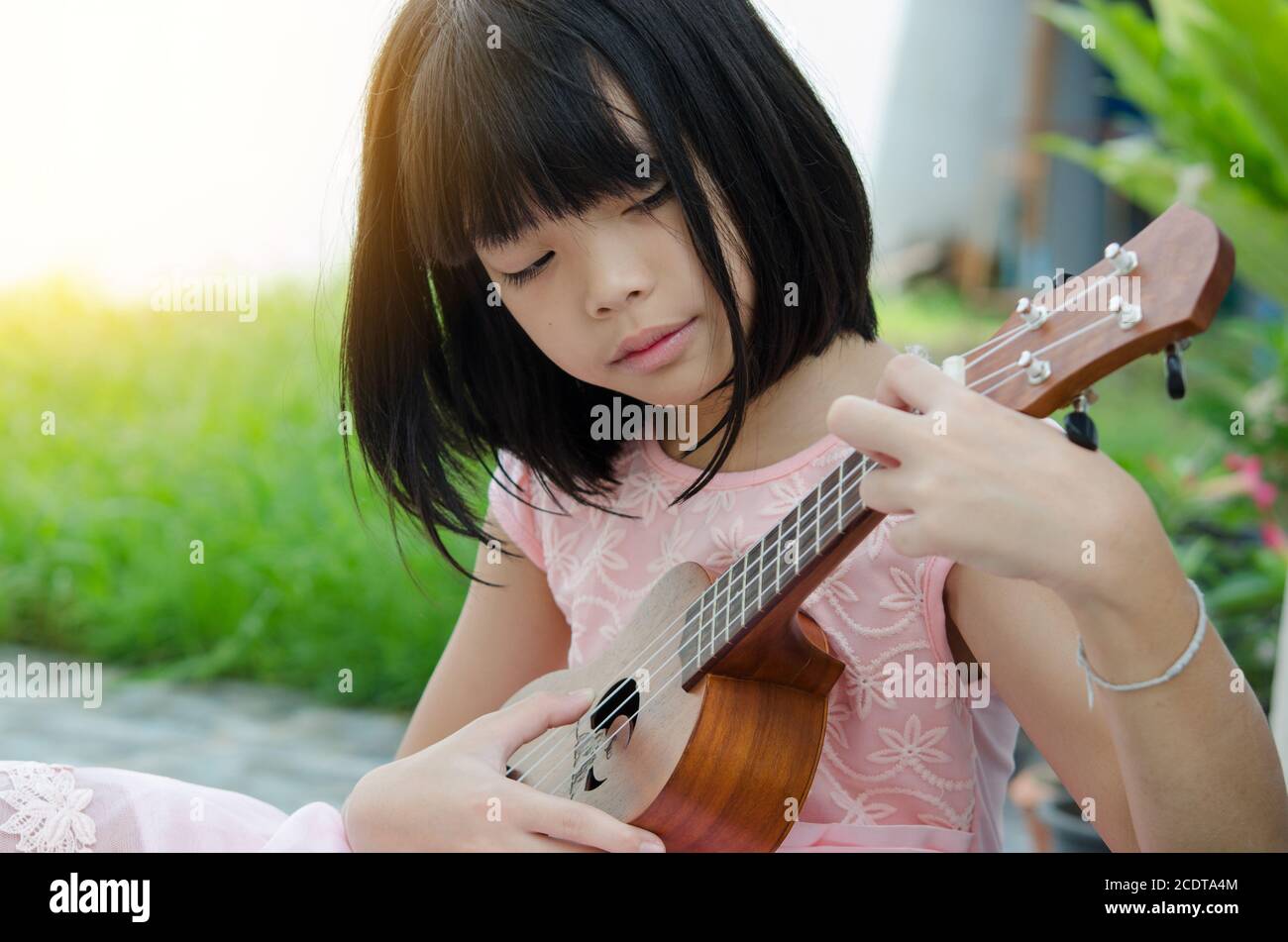 Asian girl playing the ukulele Stock Photo