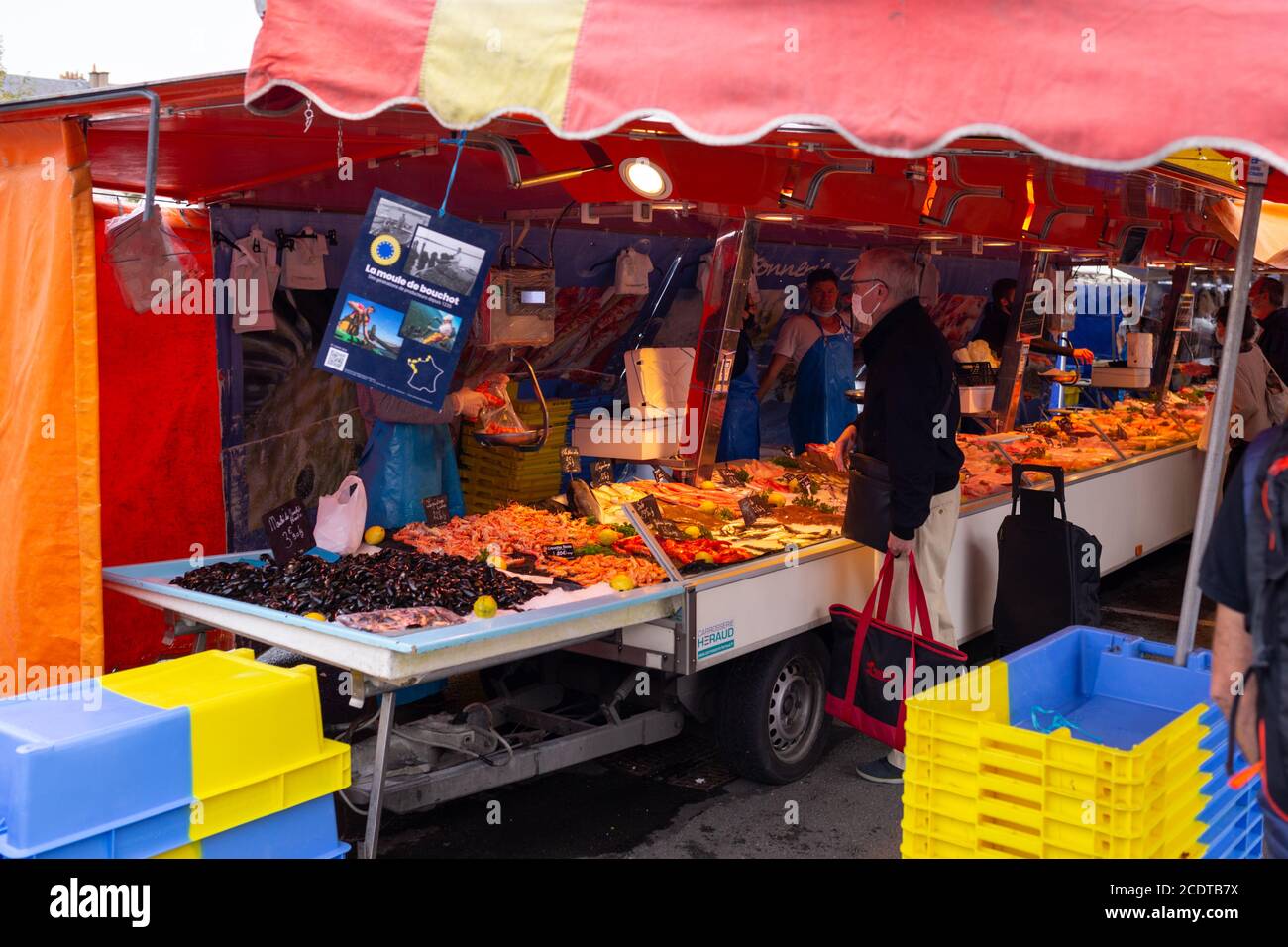 Angers, France - August 29 2020: people wearing face protective mask while shopping in the market place at France to prevent coronavirus, concept of wearing masks outdoor is mandatory, mask mode in Europe Stock Photo