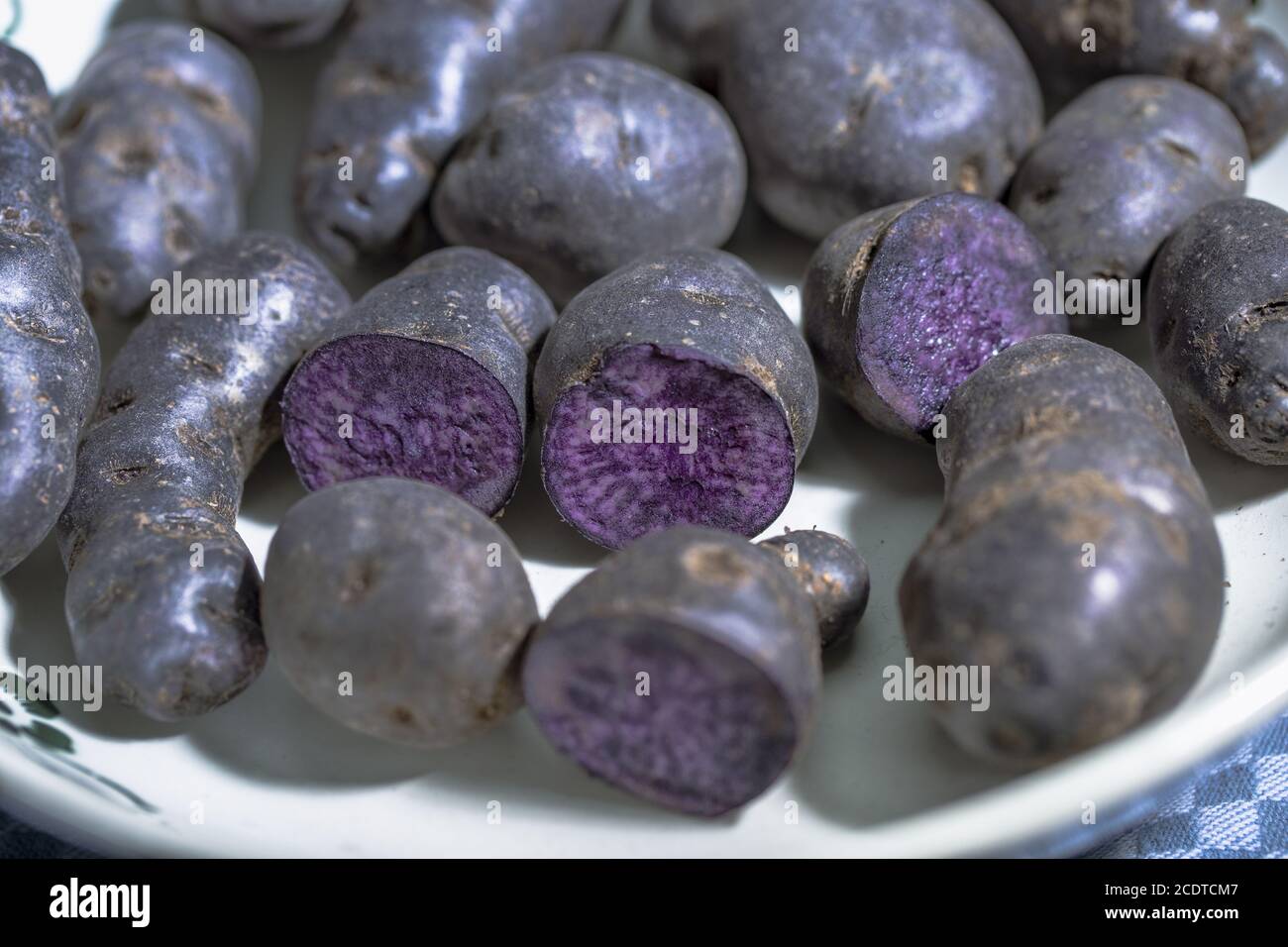 Truffle potato, Vitelotte, Blue-violet potatoes in a nostalgic bowl Stock Photo