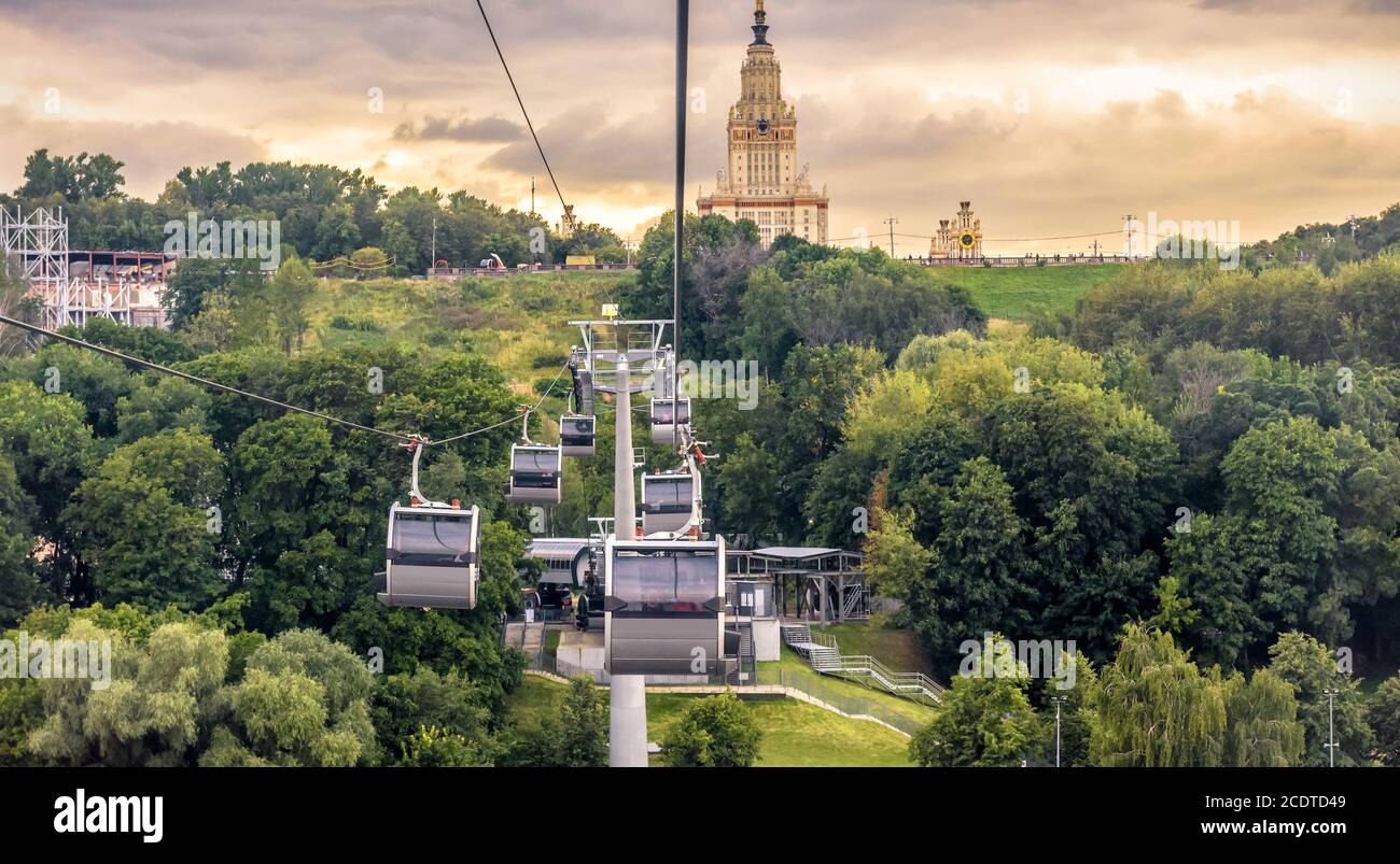 Landscape of Moscow at sunset, Russia. Scenic panoramic view of cable car and Moscow State University on Sparrow Hills. Cableway cabins move over park Stock Photo