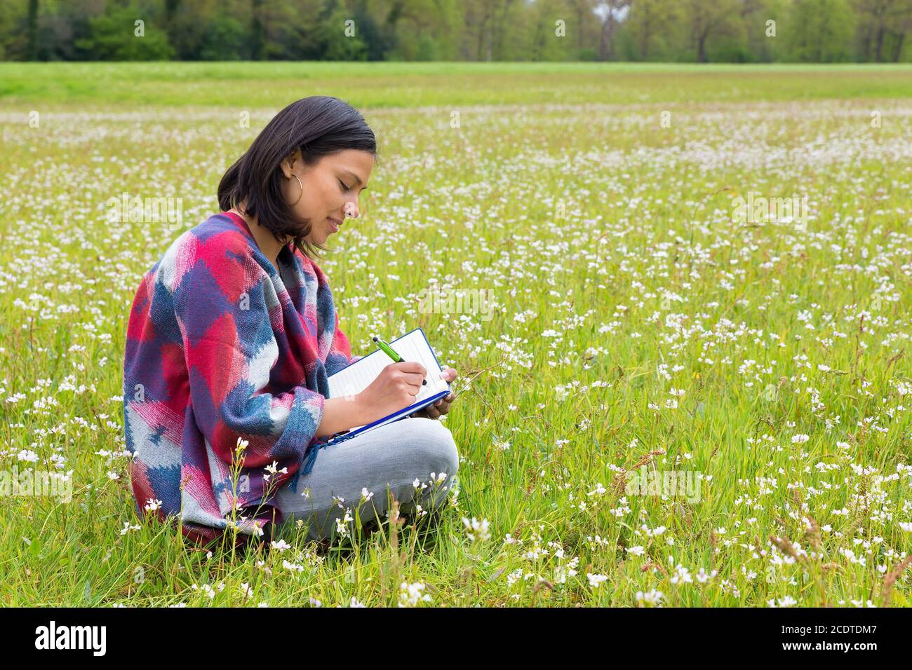 Woman writing in blooming dutch meadow Stock Photo
