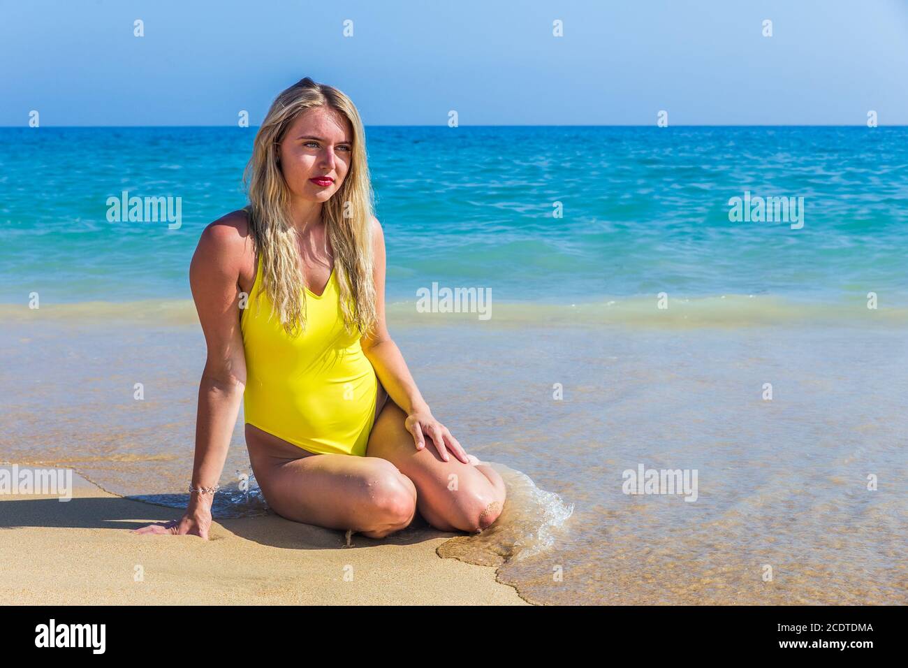 Pretty dutch girl sitting on beach near sea Stock Photo