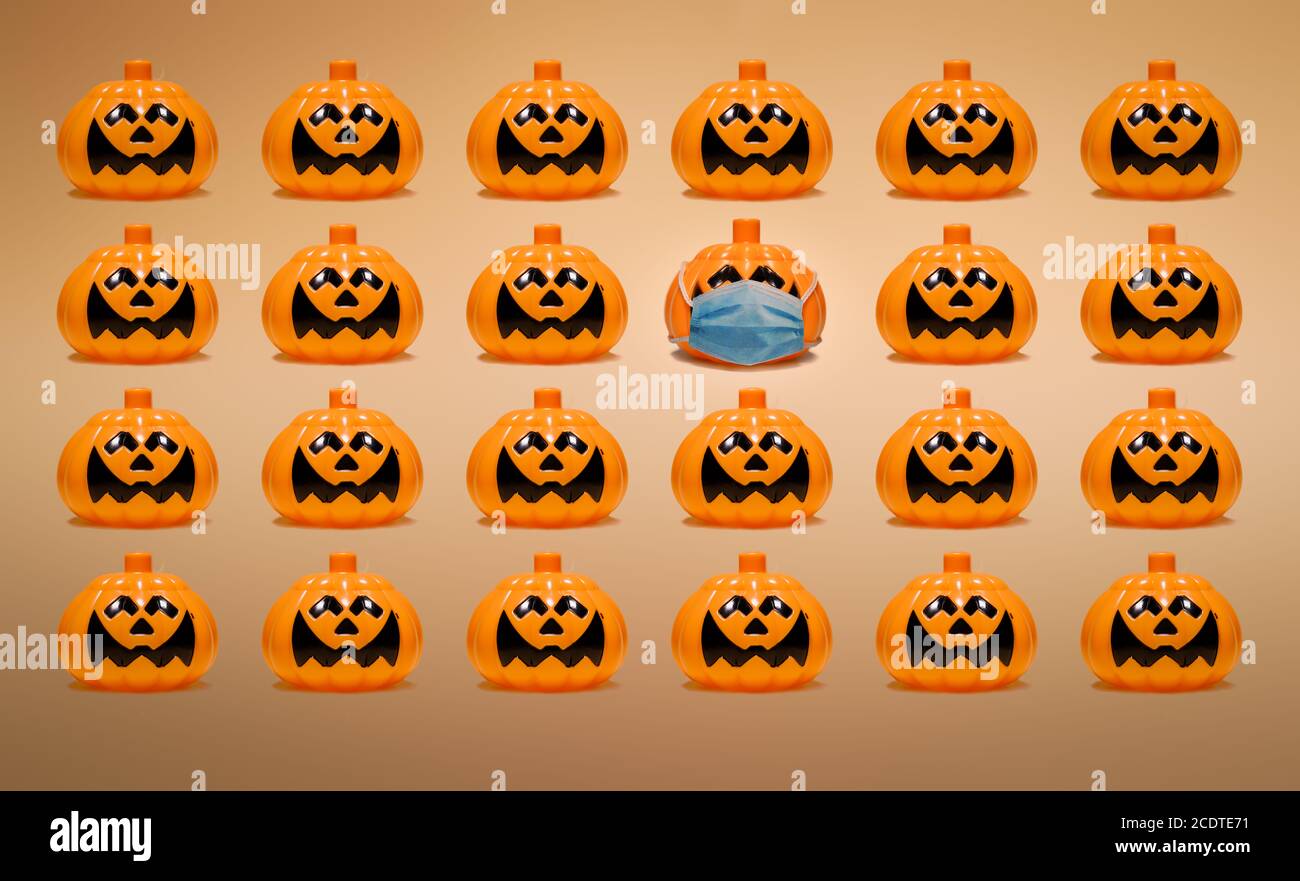 Halloween pumpkin with face mask standing out from the crowd Stock Photo