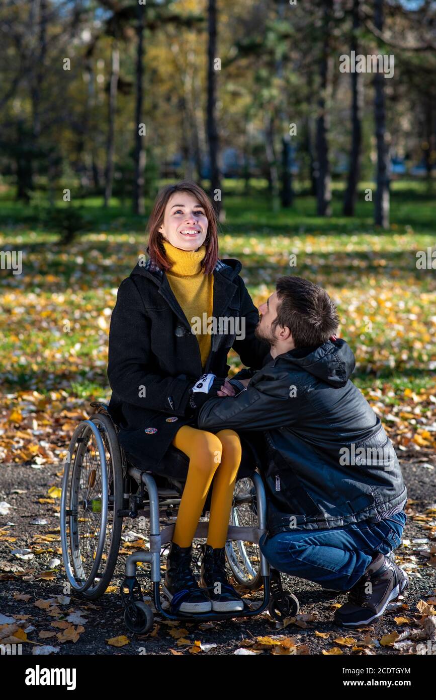 Young disabled woman in a wheelchair with boyfriend. Man with disabled girl in a wheelchair Stock Photo