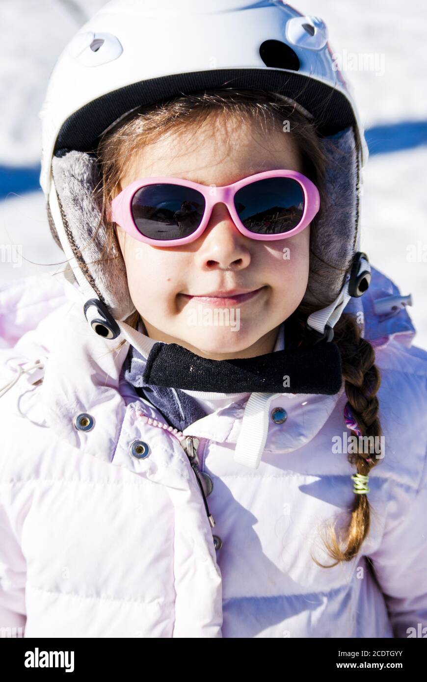 5 year old girl dressed to go skiing with helmet and glasses Stock