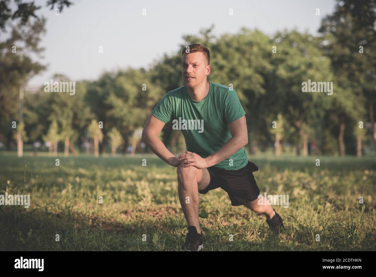 Guy stretching legs during warming-up for jogging Stock Photo