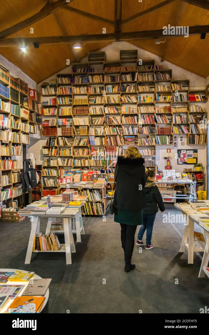 Single mother in Óbidos Portugal mother and daughter walking on vintage beautiful library bookstore. Walking on bookstore culture amd poetry. Stock Photo
