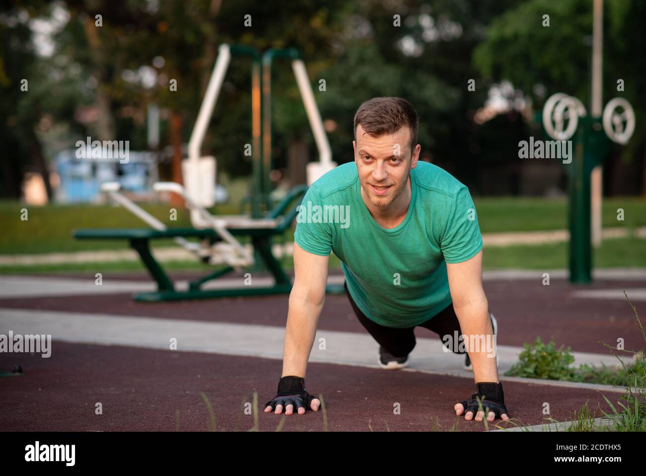 Guy doing push-ups in outdoor gym Stock Photo