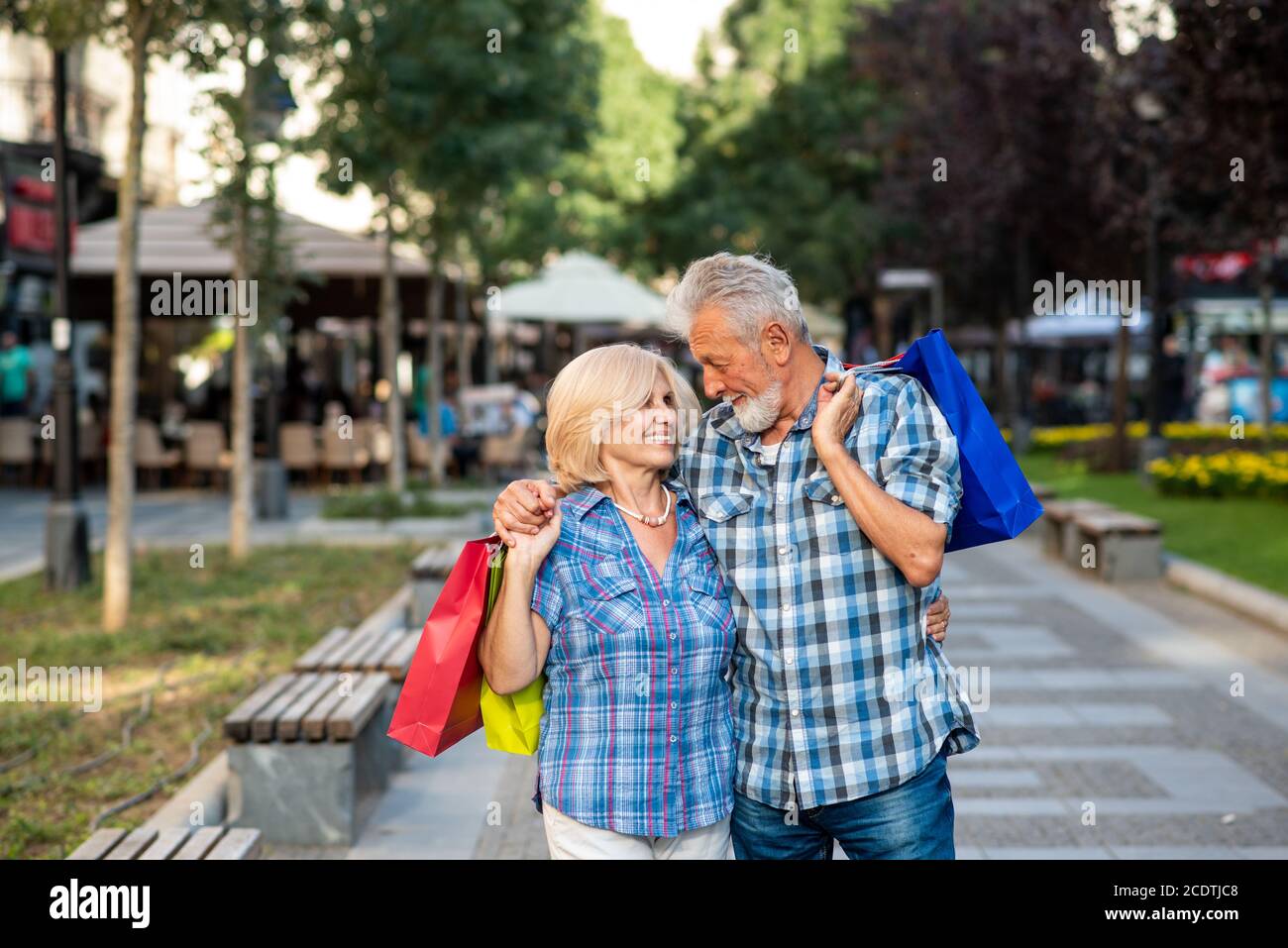 Happy senior couple hugging after shopping Stock Photo