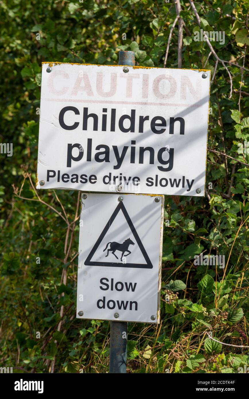 Children playing, caution, please drive slowly, slow down, horses, signs in Great Wakering, near Southend, Essex, UK. Rural, country road Stock Photo