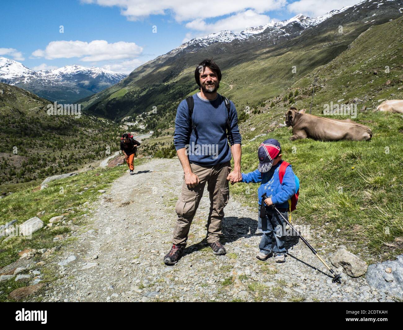 father holds his son by the hand during a hike in the mountains Stock Photo