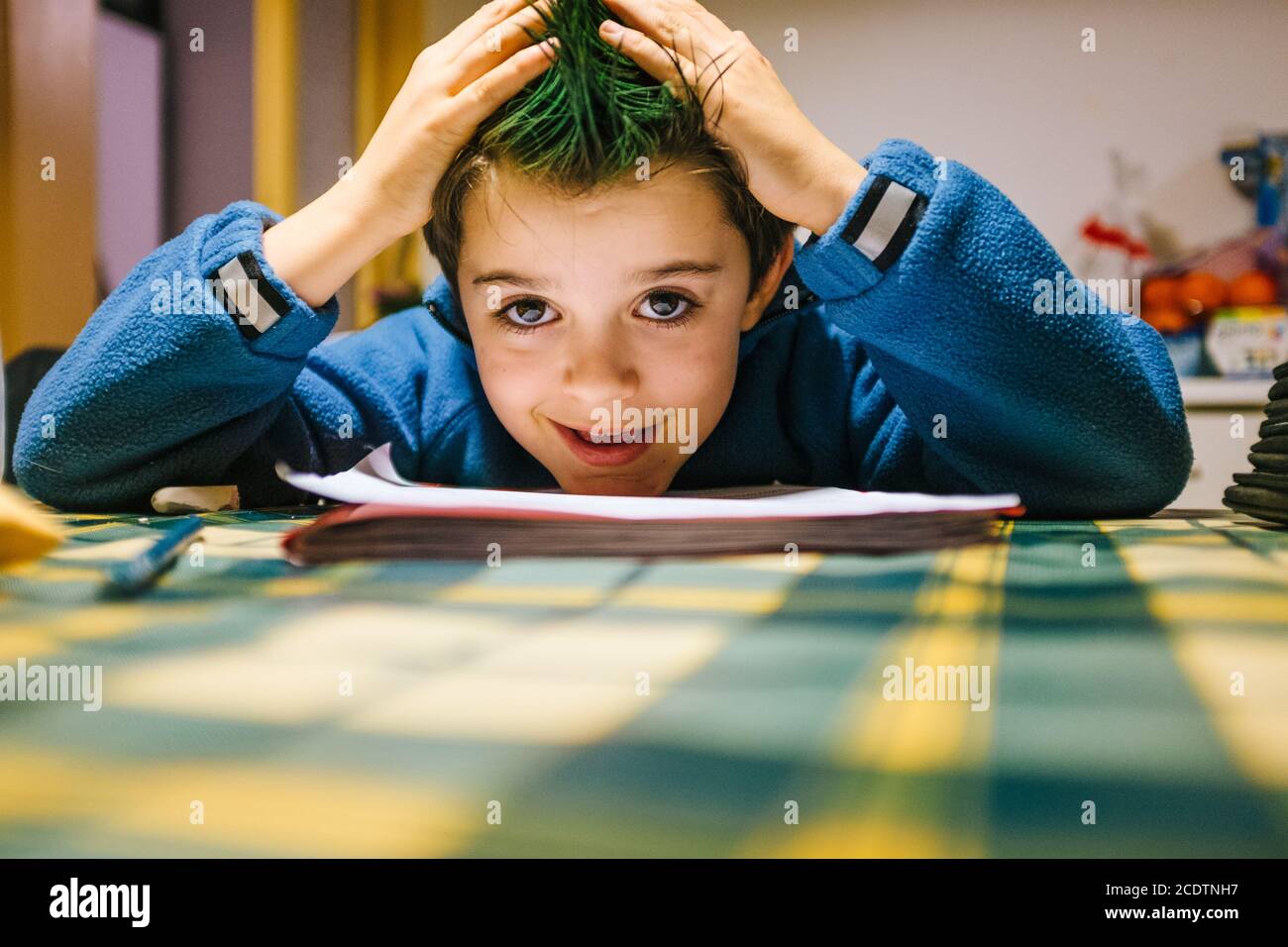 portrait of 9 year old baby boy with crest of green colored hair Stock Photo