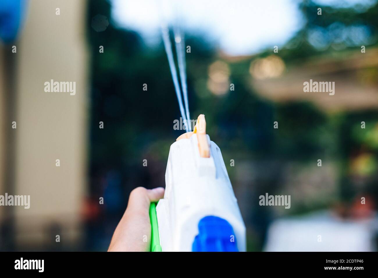 children play in the garden with guns and water rifles on a sunny summer day Stock Photo
