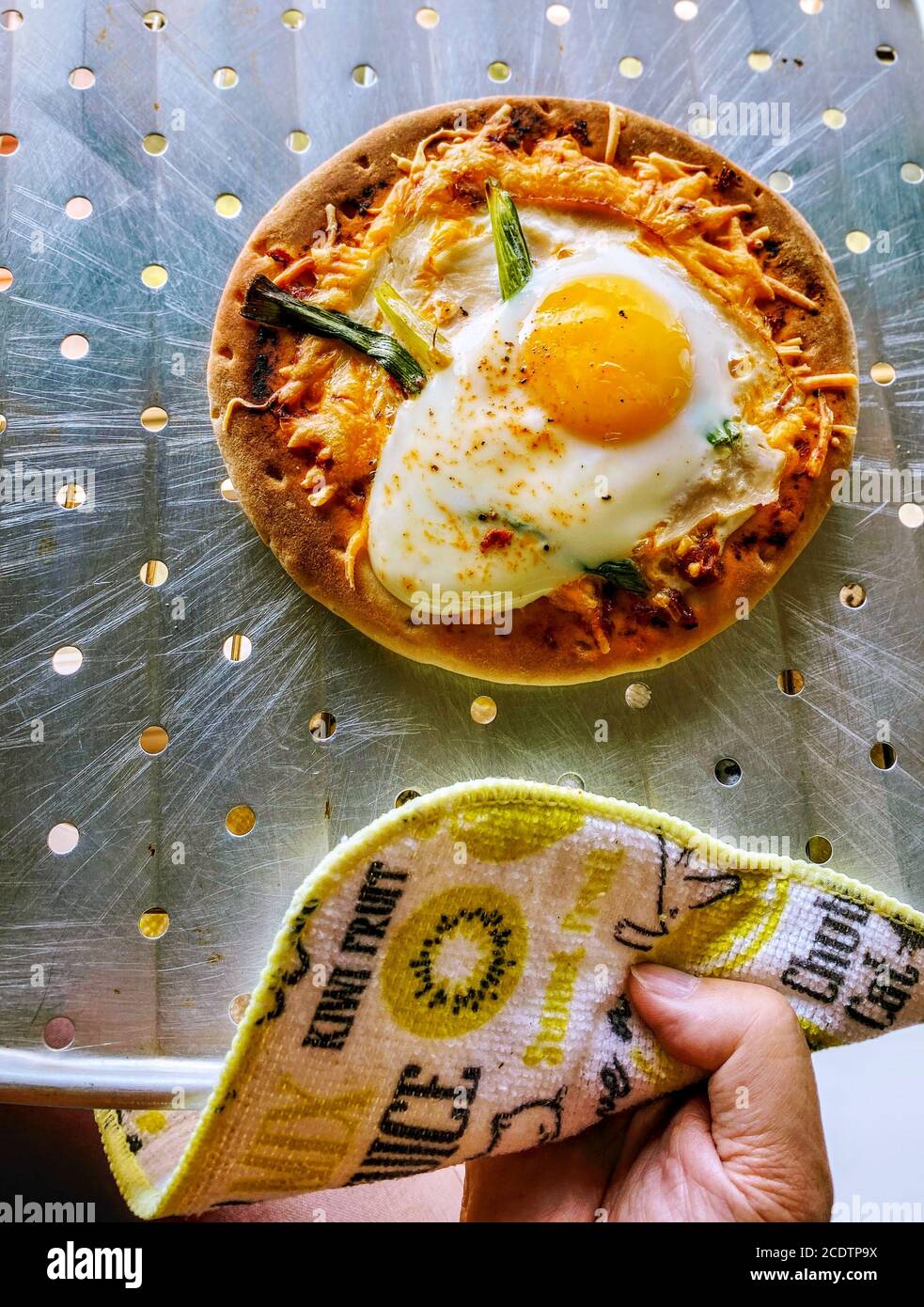 Fresh breakfast pizza from the oven with sunny side egg, scallions and cheese Stock Photo